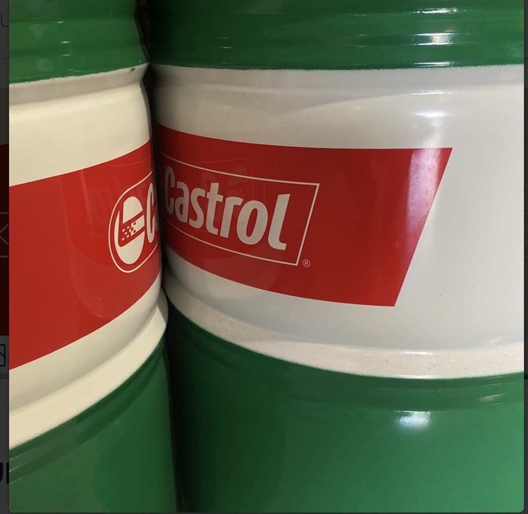 Close-up of green and white oil drums in the workshop
