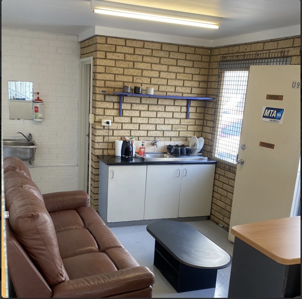 The waiting area with a leather couch, a kitchenette and the office door marked U9